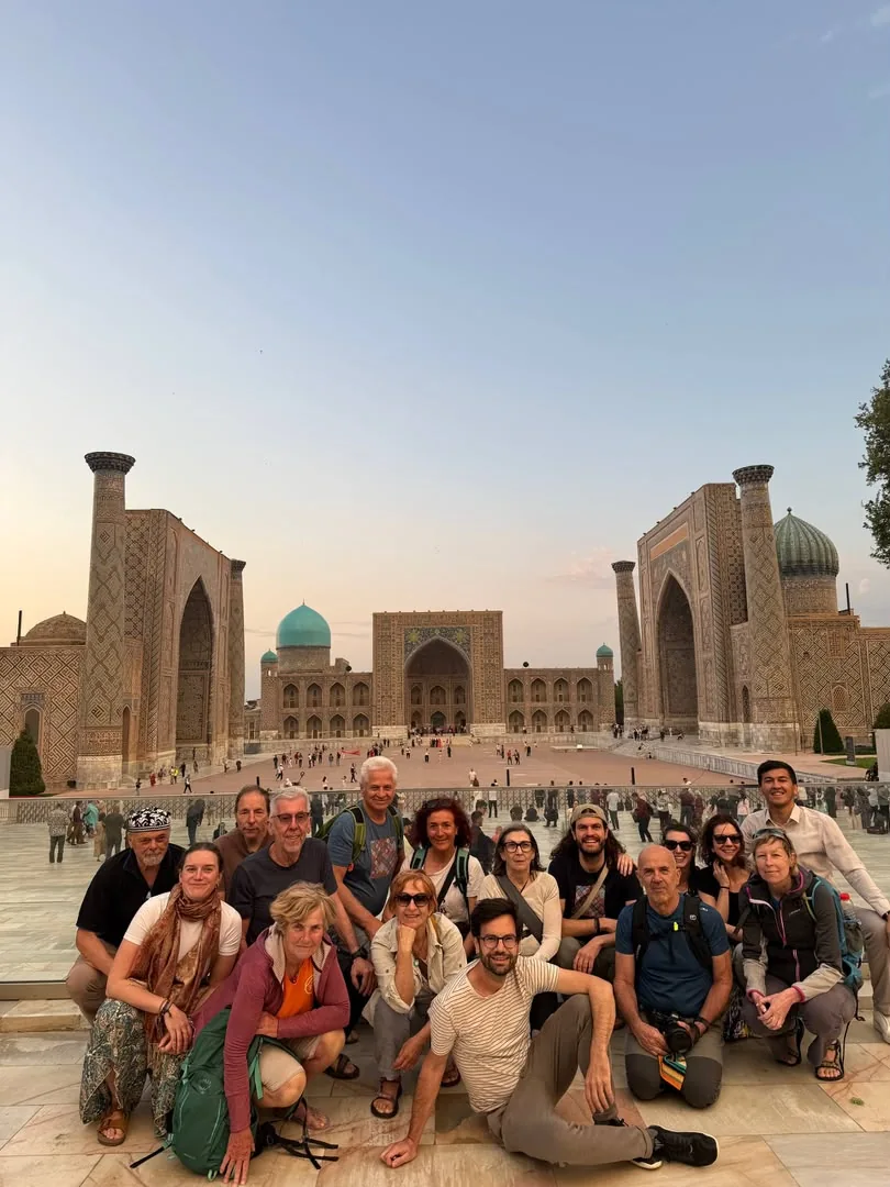 Travelers posing together in front of the Registan madrasahs