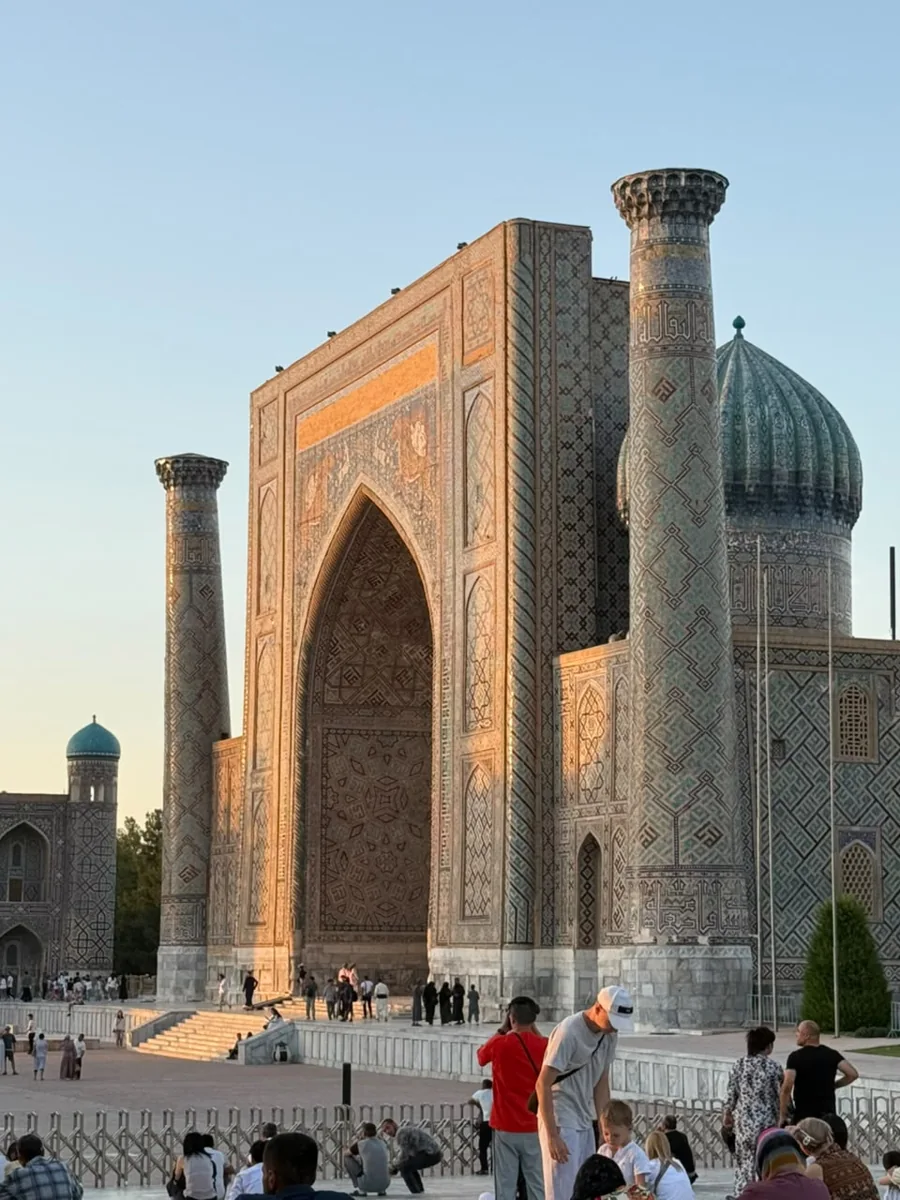A tiled madrasah entrance and turquoise dome at the Registan in Samarkand