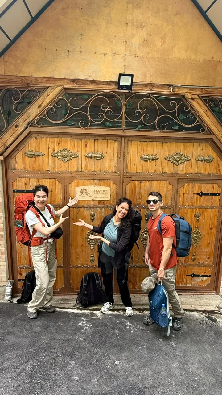 Travelers standing beside an ornate historic wooden doorway