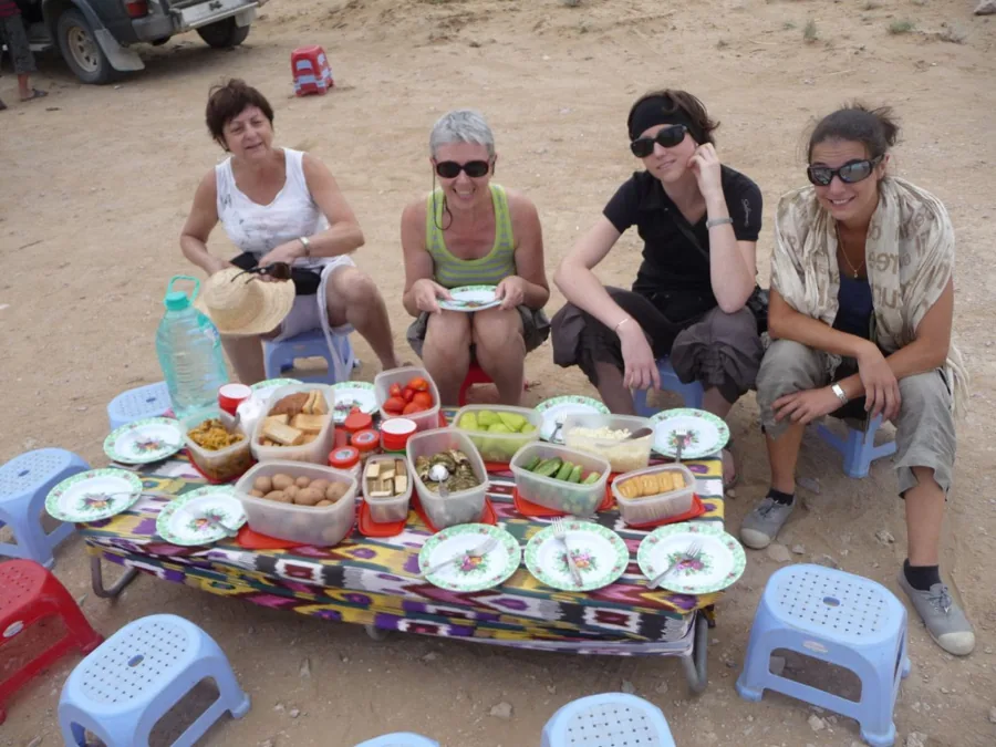 Travelers sitting around a low breakfast table outdoors