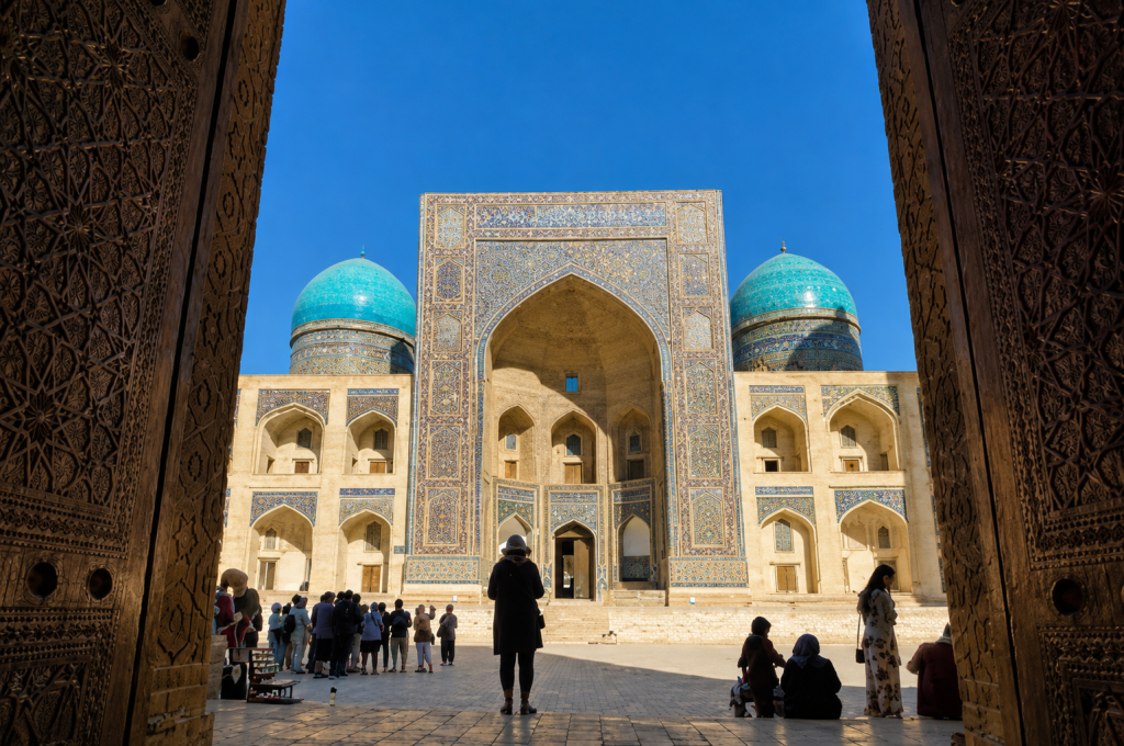 38a35ed0-3ccc-4a92-8ccc-b1d9704fba0a - Silk Road Elite - Silk Road Elite Grand Islamic madrasa with turquoise domes under a blue sky