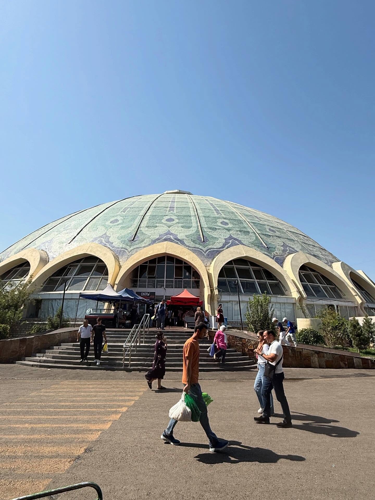 Visitors outside the blue-domed Chorsu Bazaar in Tashkent. - Silk Road Elite - Silk Road Elite Visitors outside the blue-domed Chorsu Bazaar in Tashkent.