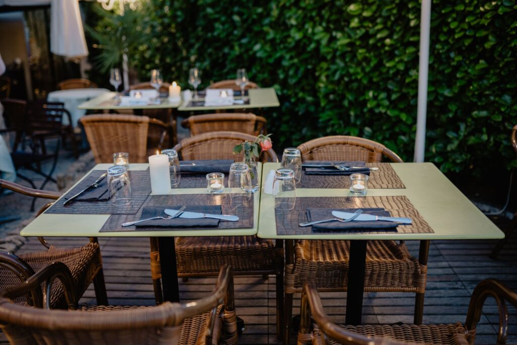 Outdoor dining table set beside a leafy garden