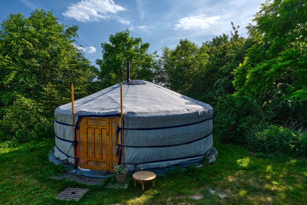 Traditional round yurt surrounded by green trees