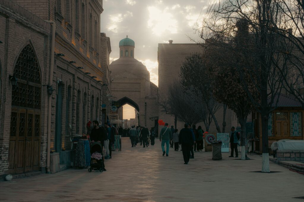 Pedestrians walking along a historic street in soft evening light