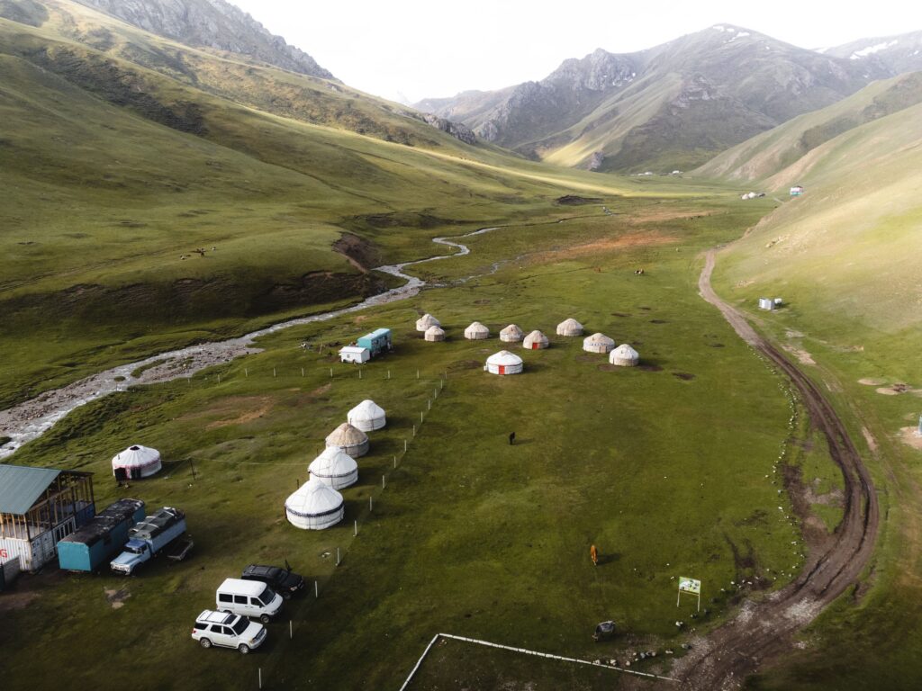 Yurt camp in a broad green mountain valley