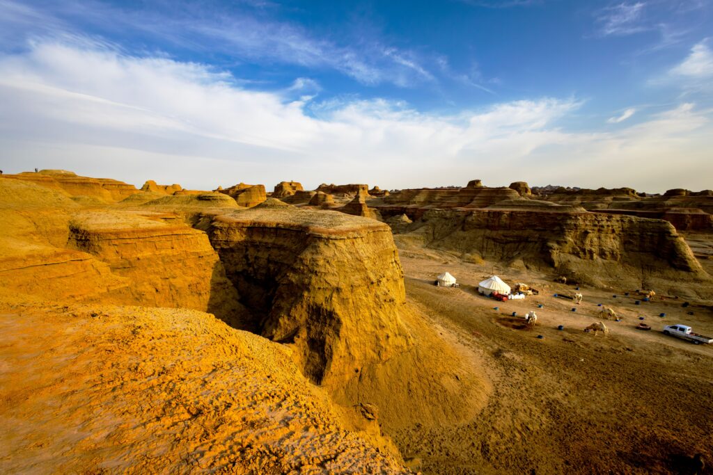 Yurt camp set among golden desert cliffs