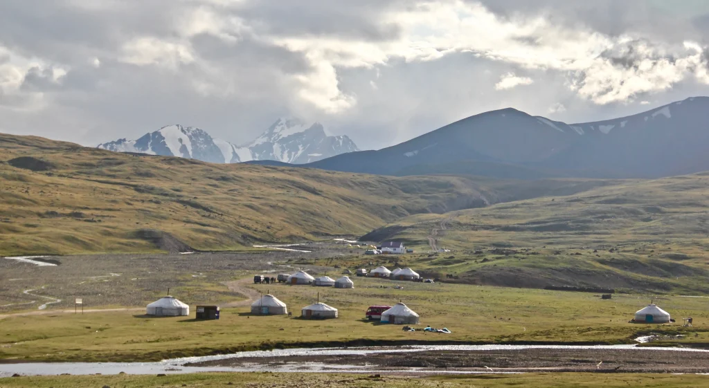wide-shot-lowlands-middle-east-with-tents-set-up-by-explorers - Silk Road Elite - Silk Road Elite Wide view of lowlands and mountains beneath cloudy skies