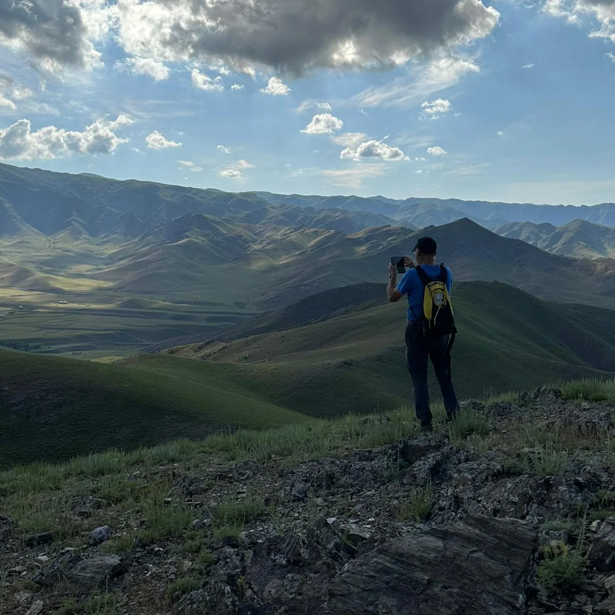 Five-Village Trek in the Nuratau Mountains - Silk Road Elite - Silk Road Elite Hiker photographing a panoramic view of the Nuratau Mountains