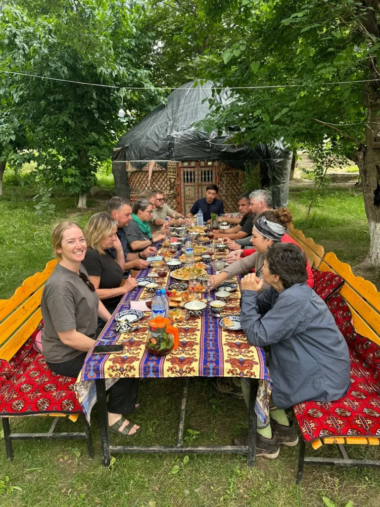 Travelers sharing a traditional outdoor meal at a Nuratau village homestay