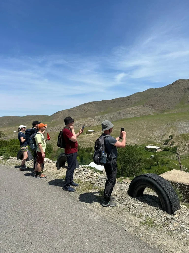 Group of hikers overlooking a mountain village in the Nuratau Mountains