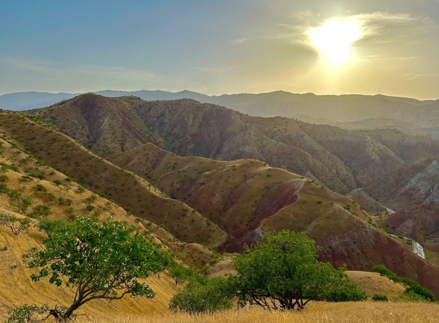 Sunlight shining over layered mountain ridges