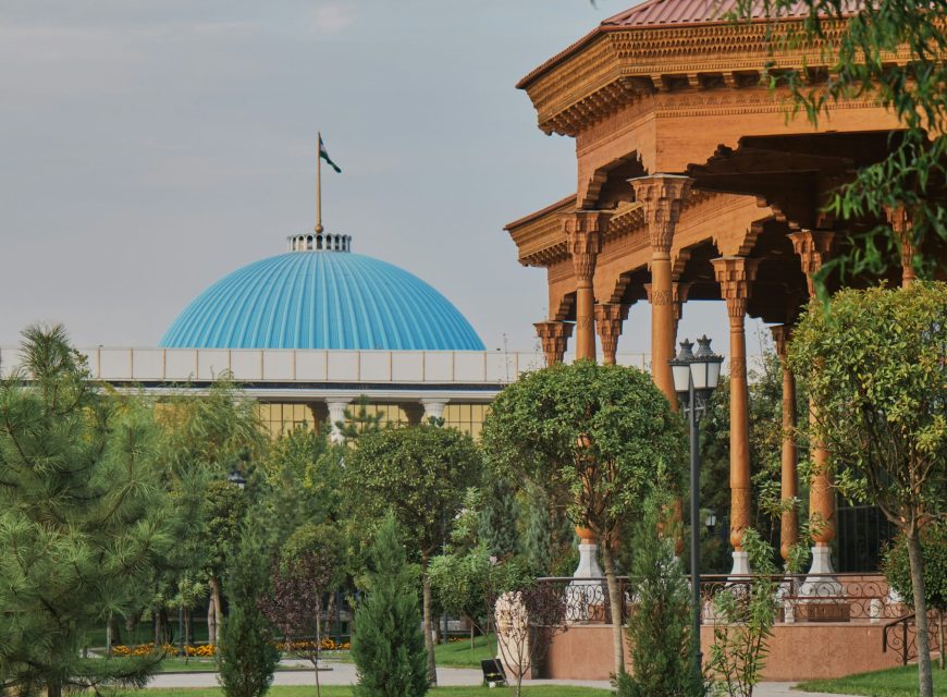Turquoise mosque dome beside an ornate wooden pavilion