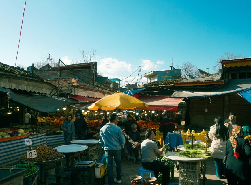 Colorful outdoor market stalls beneath a bright blue sky