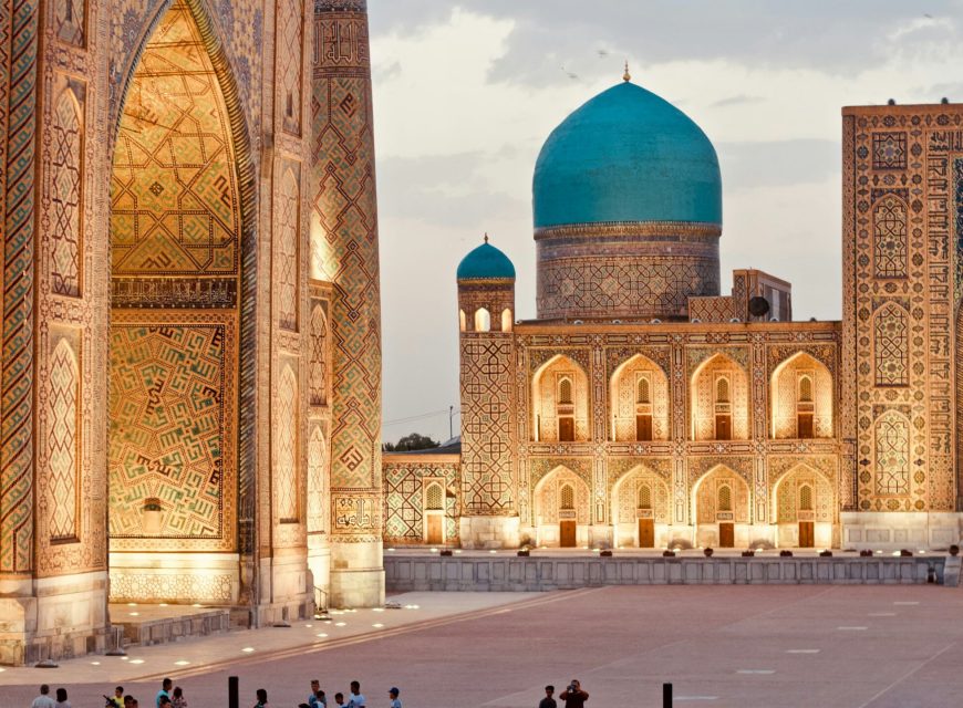 Historic archway framing a turquoise dome and minaret