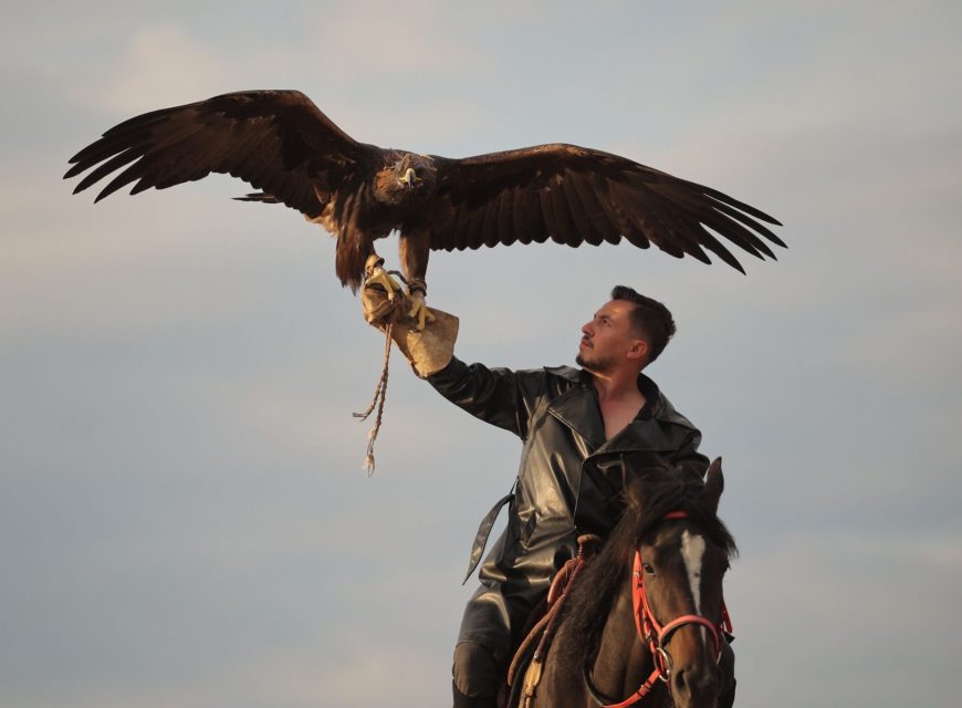 Traditional eagle hunter holding a golden eagle