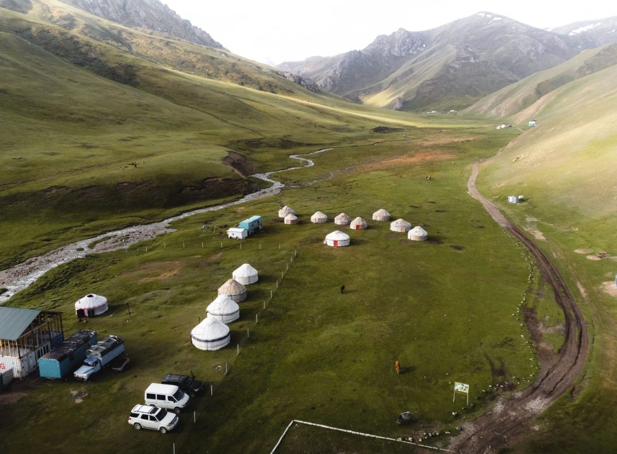 Yurt camp in a broad green mountain valley