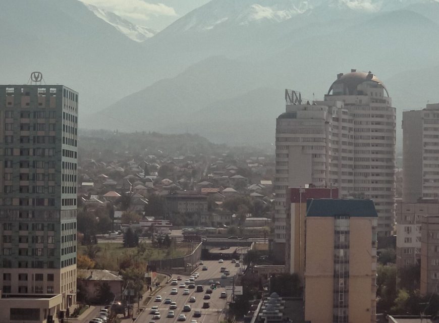 City buildings surrounded by misty mountains
