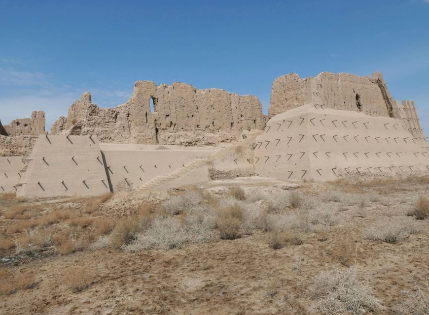 Ancient mud-brick fortress ruins under a clear blue sky