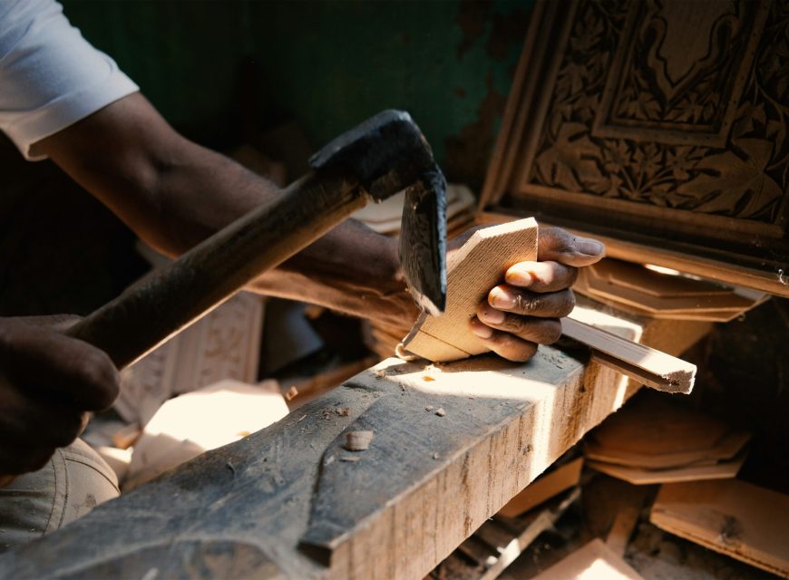 Traditional craftsman carving wood with a hand tool
